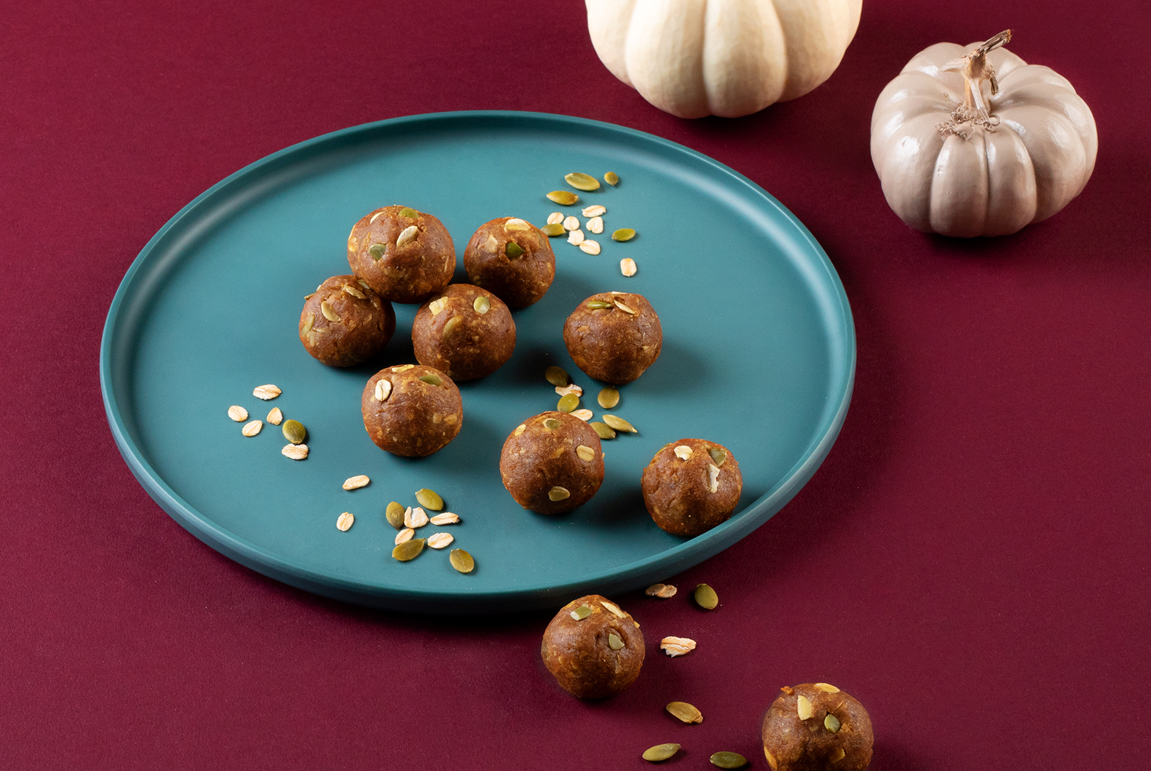 Pumpkin spice bites neatly arranged on a plate stylized with pumpkin seeds. 