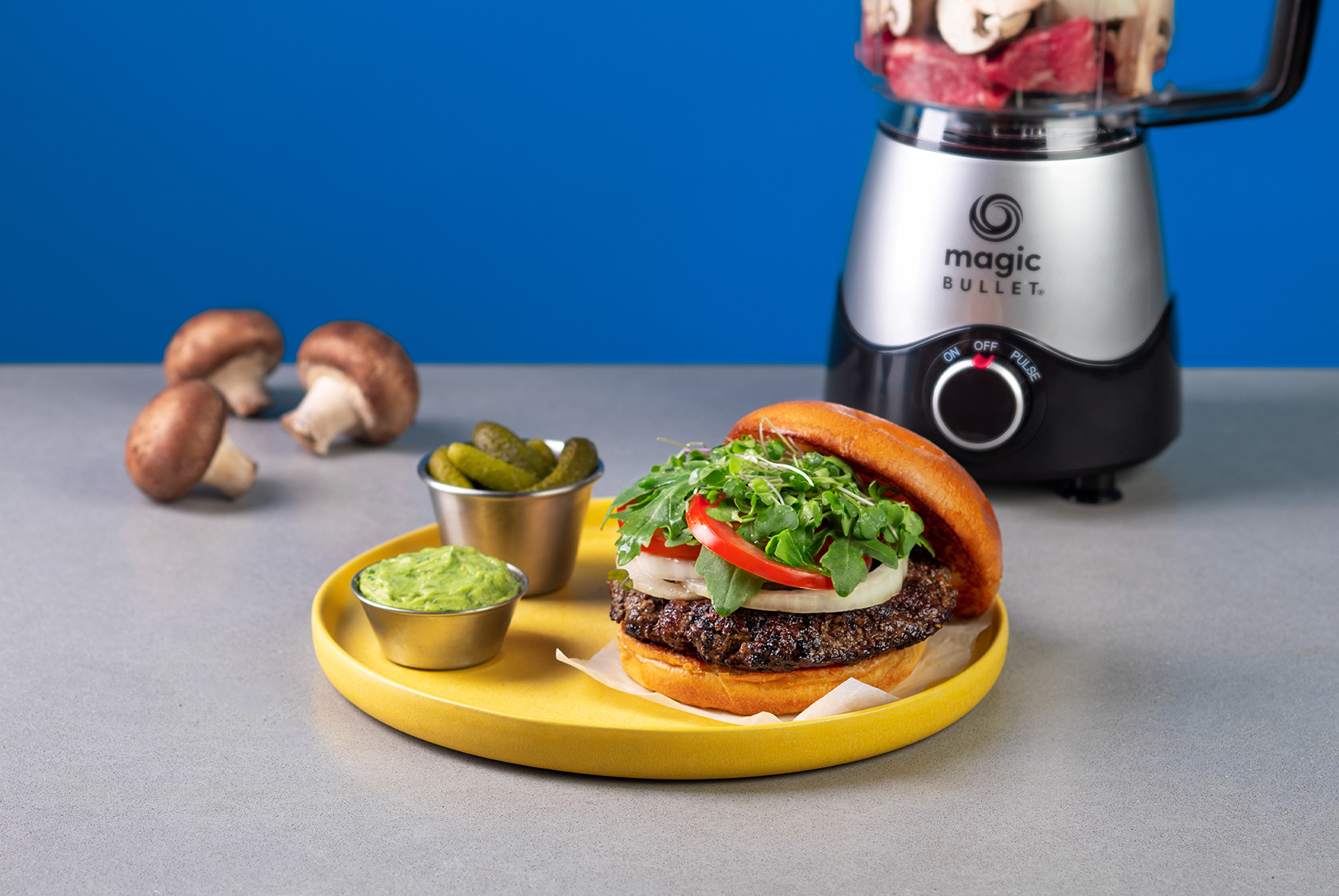 plate of beef and mushroom hamburger with guacamole and gherkins 