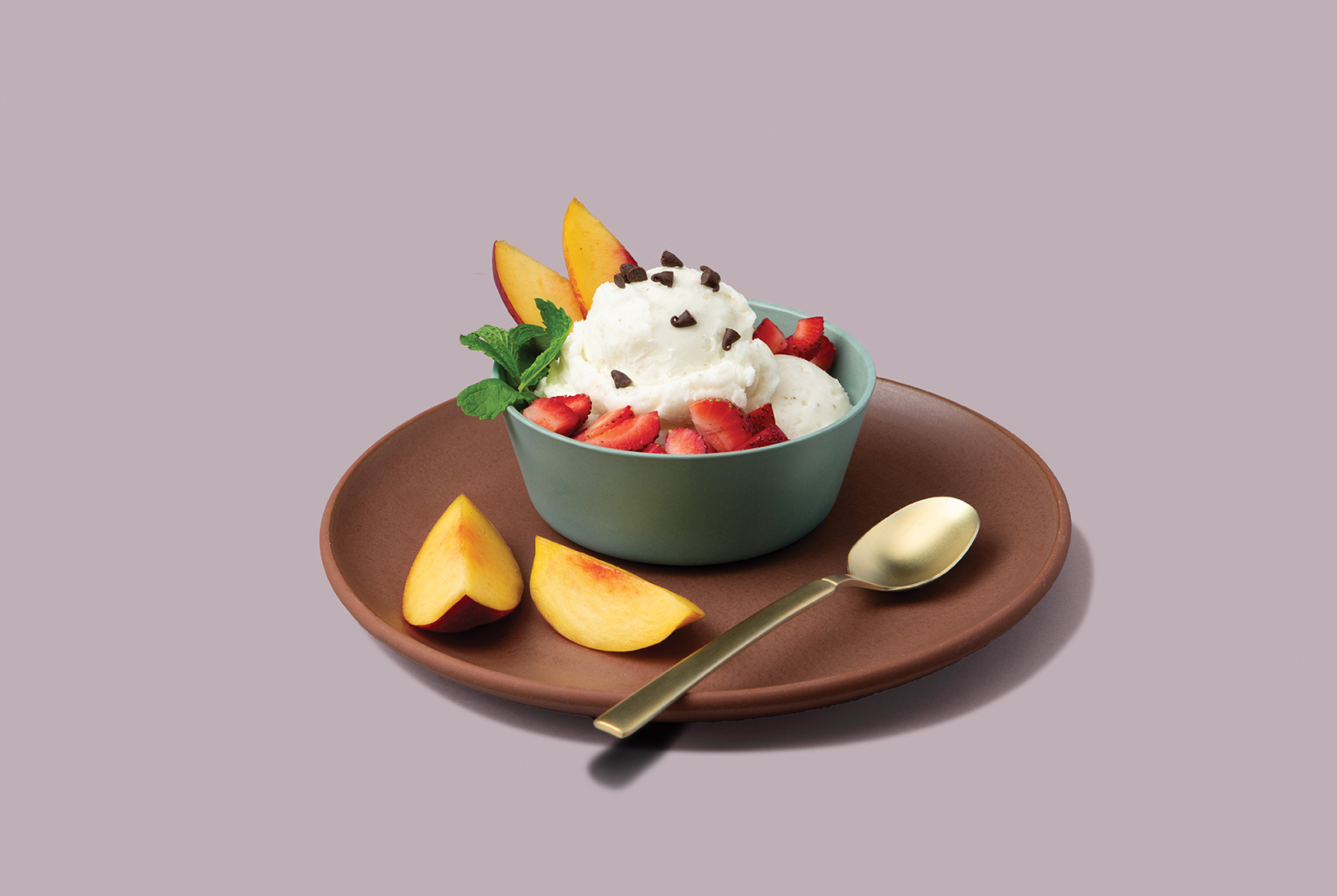 bowl of banana vanilla ice cream with fresh berries, nectarine, and cacao nibs