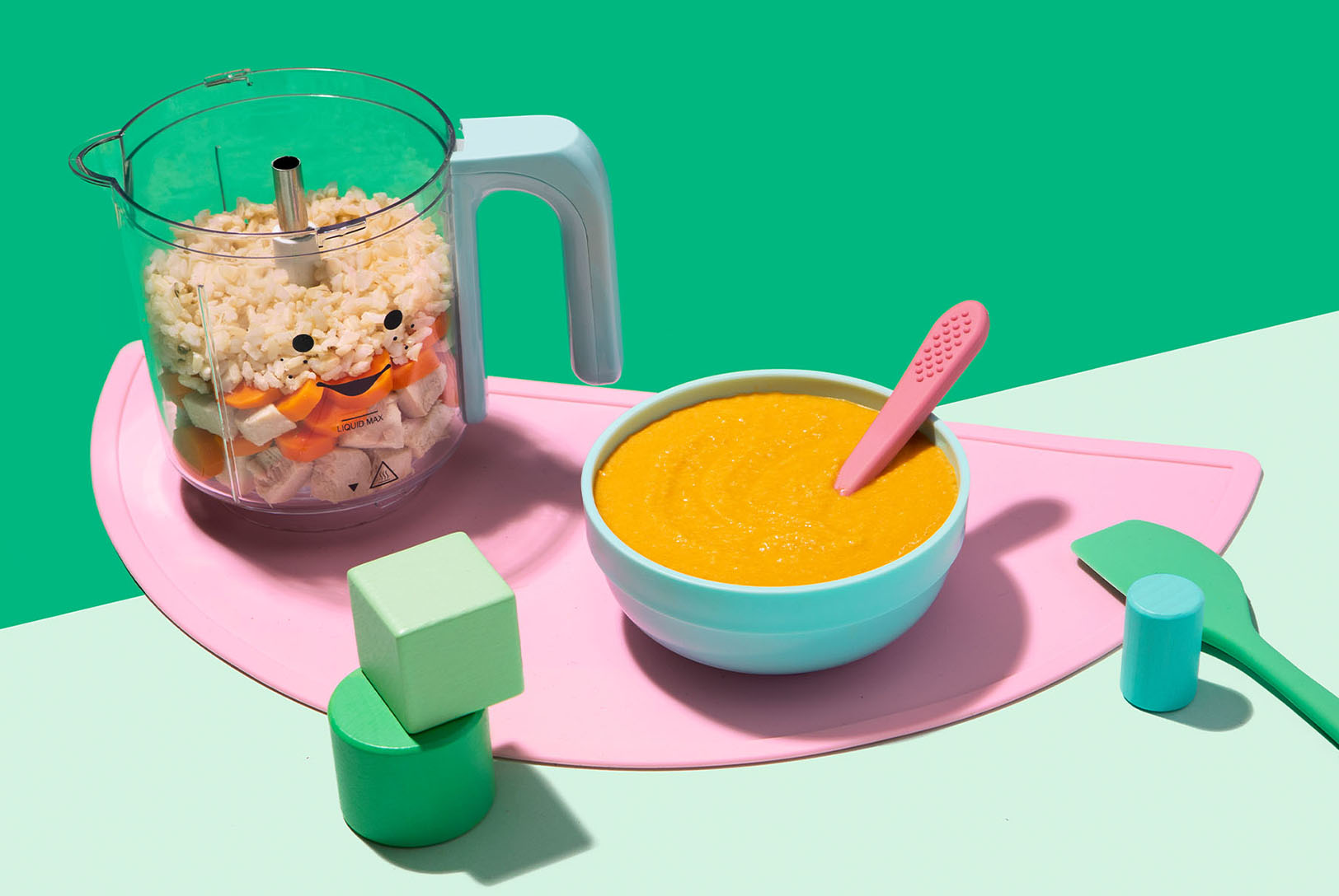 Blender full of chicken, rice and veggies next to a bowl of pureed ingredients