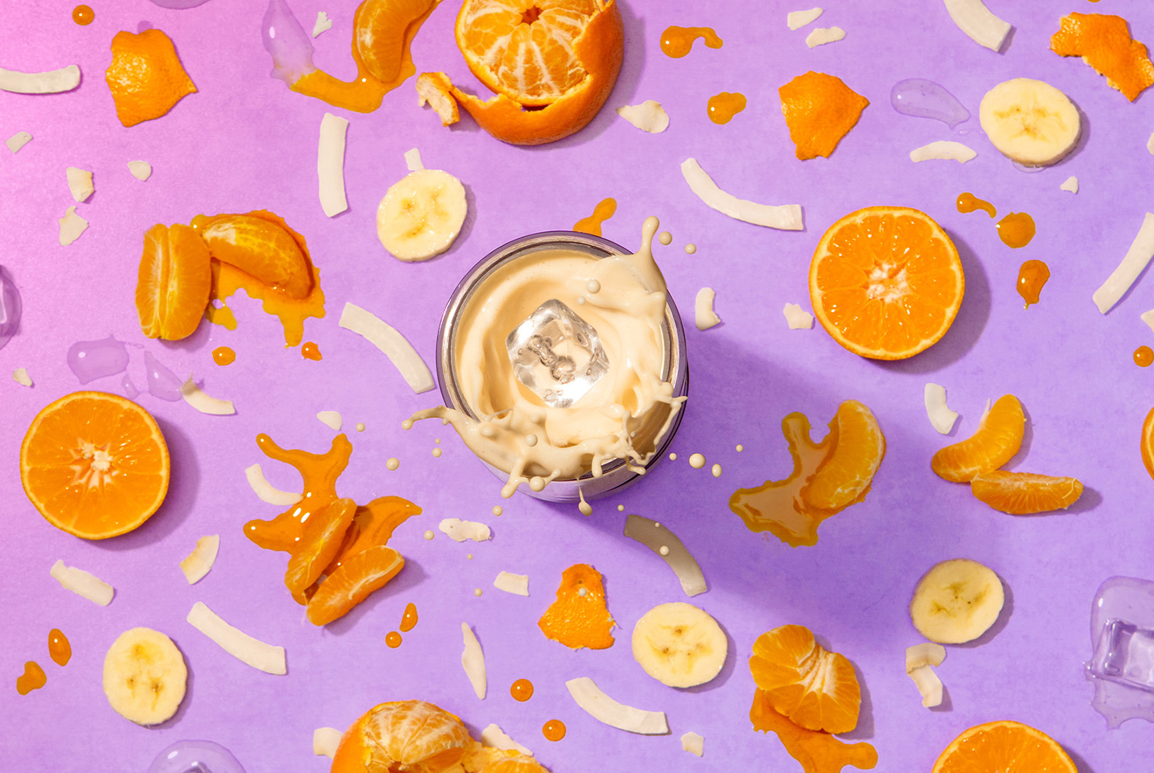 creamy orange creamsicle smoothie made in magic bullet Portable Blender surrounded by orange slices, banana slices, and coconut