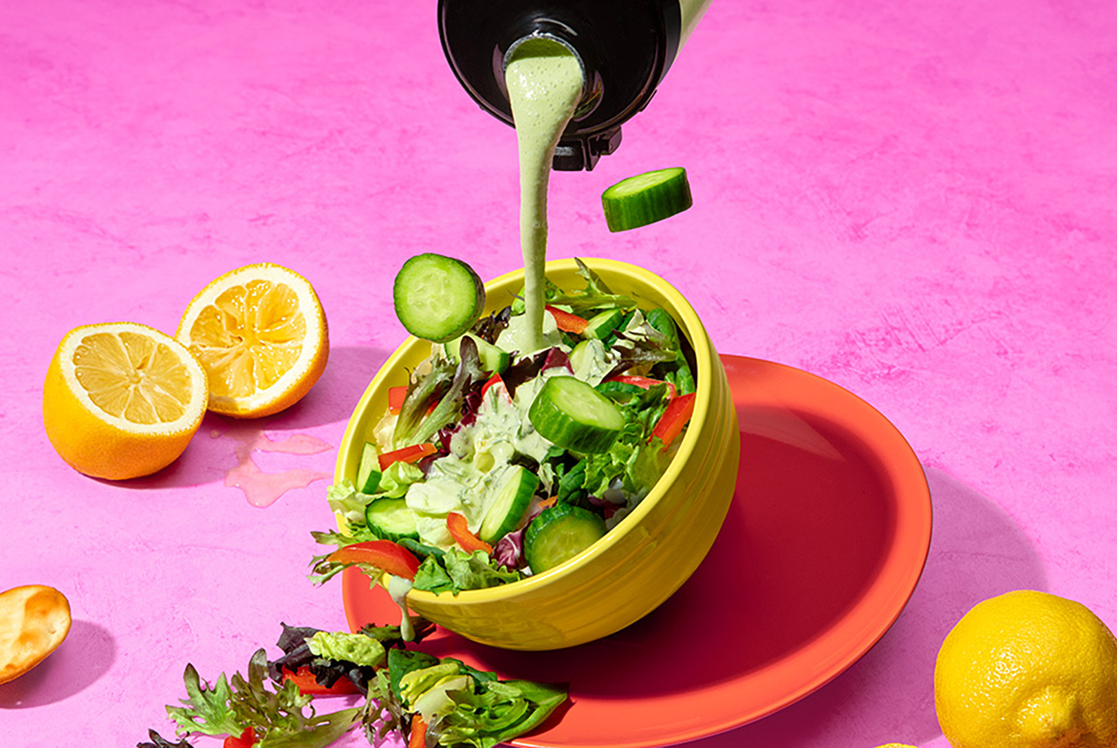 cucumber dill dressing in magic bullet Portable Blender being poured over leafy green salad 