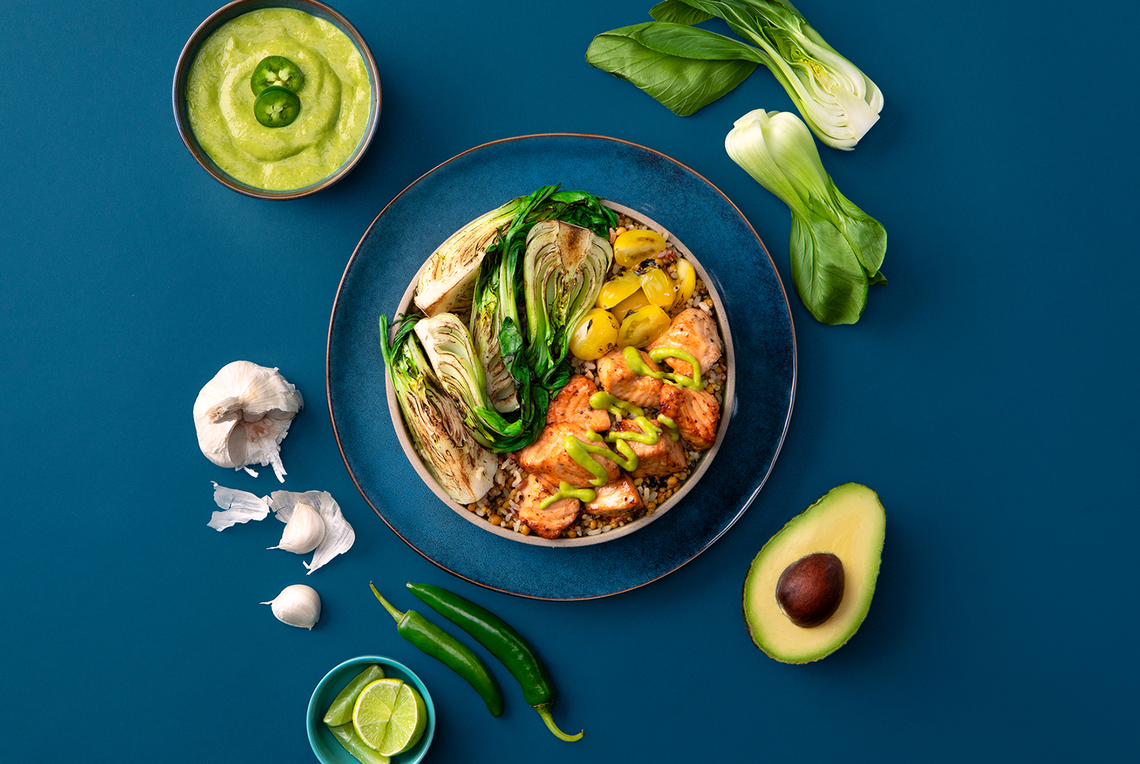 salmon, bok choy, and grain bowl topped with spicy garlic avocado salsa 