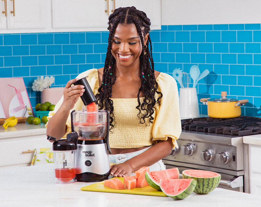 Image of a woman in the kitchen making watermelon juice with the magic bullet Mini Juicer.