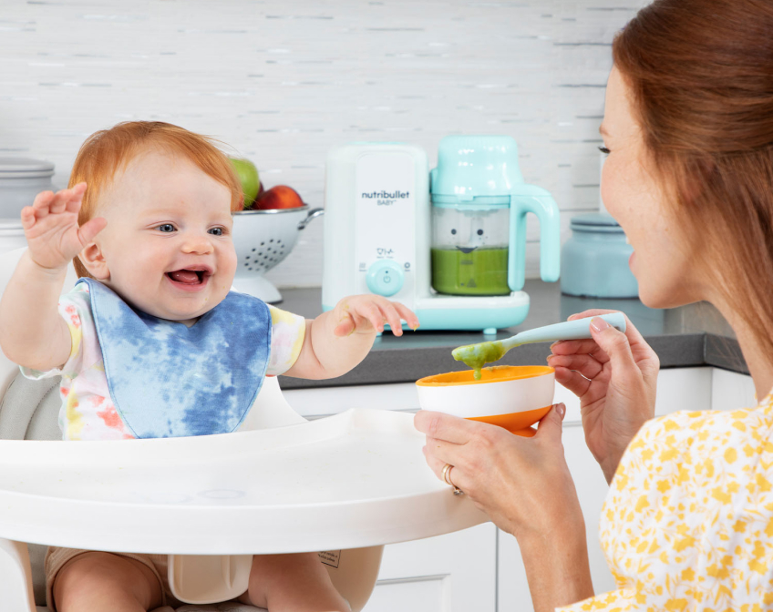 Mother feeding child in white high chair