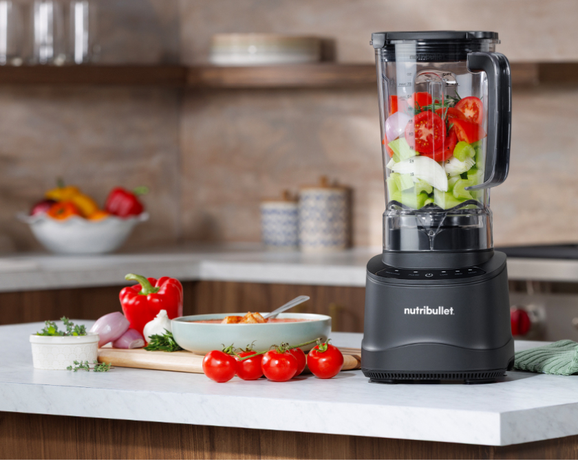 nutribullet Power Core Blender on kitchen counter surrounded by smoothies, soup bowls, and fresh ingredients
