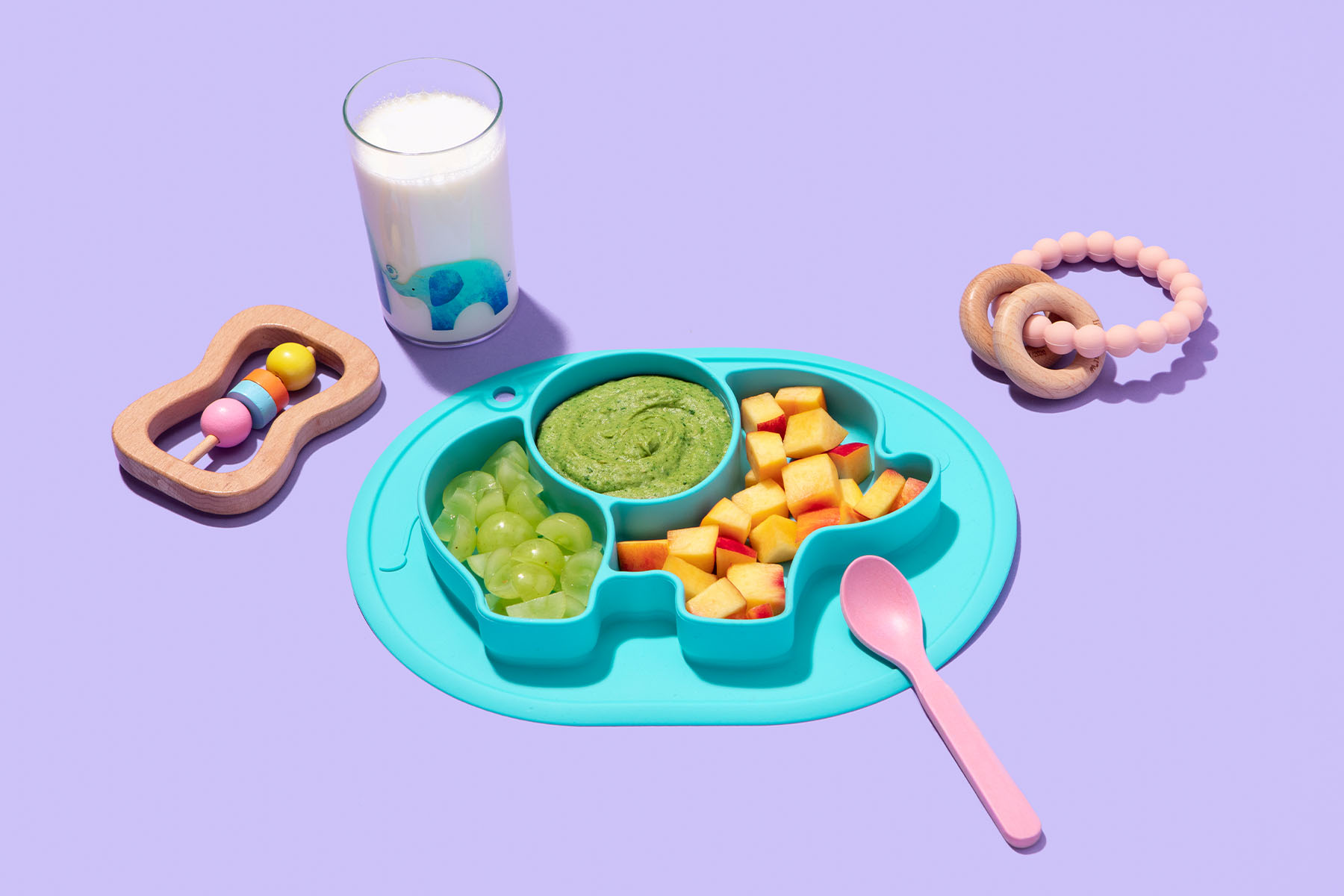 Plate of toddler food with pureed blend and fruits with glass of milk