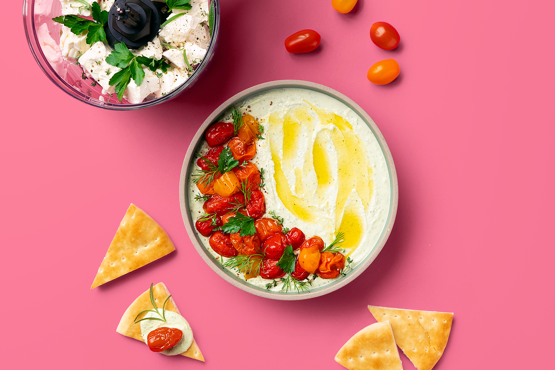 feta dip topped with sliced cherry tomatoes, olive oil, and herbs