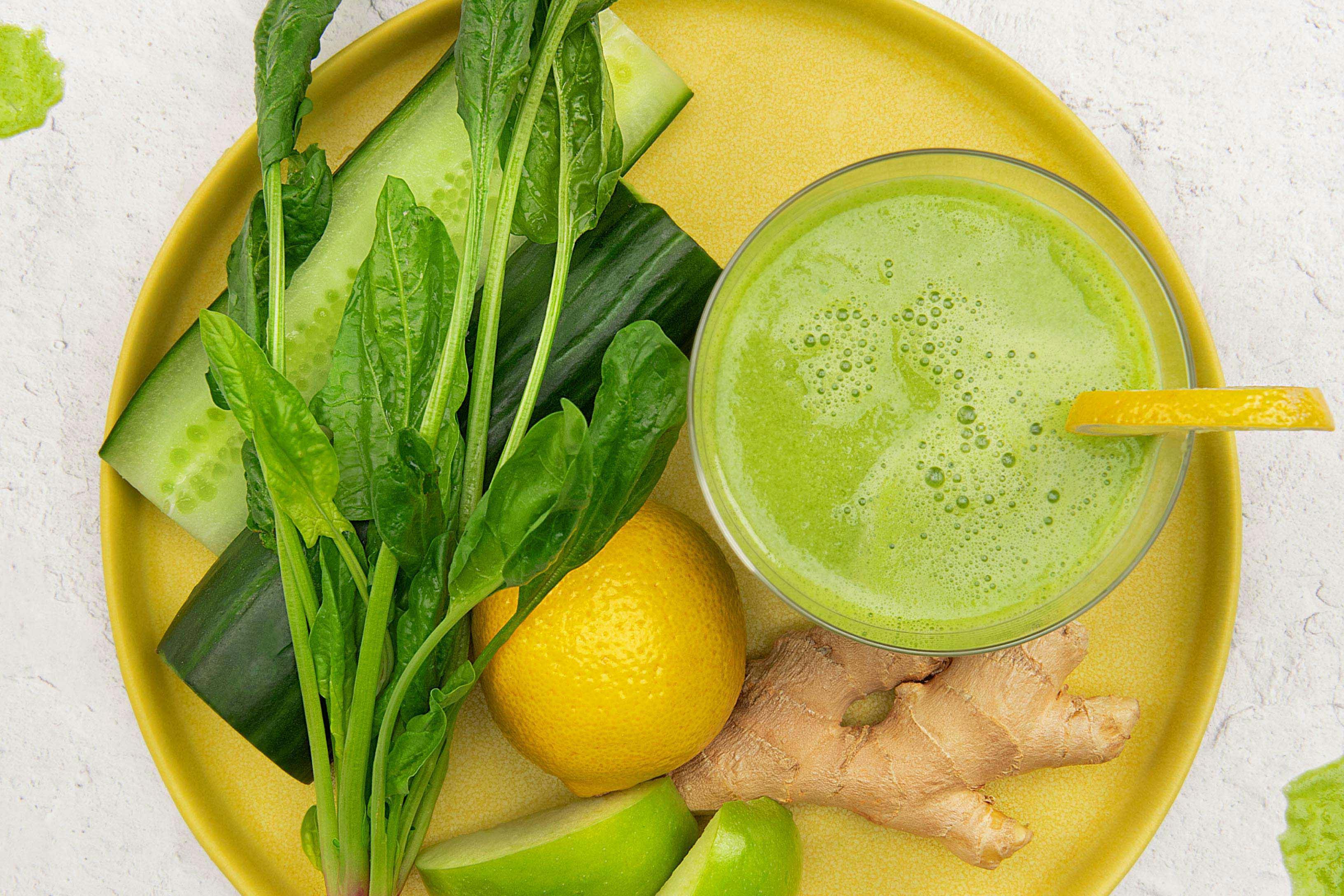 overhead image of Gingery Green juice next to cucumber, spinach, lemon, and ginger