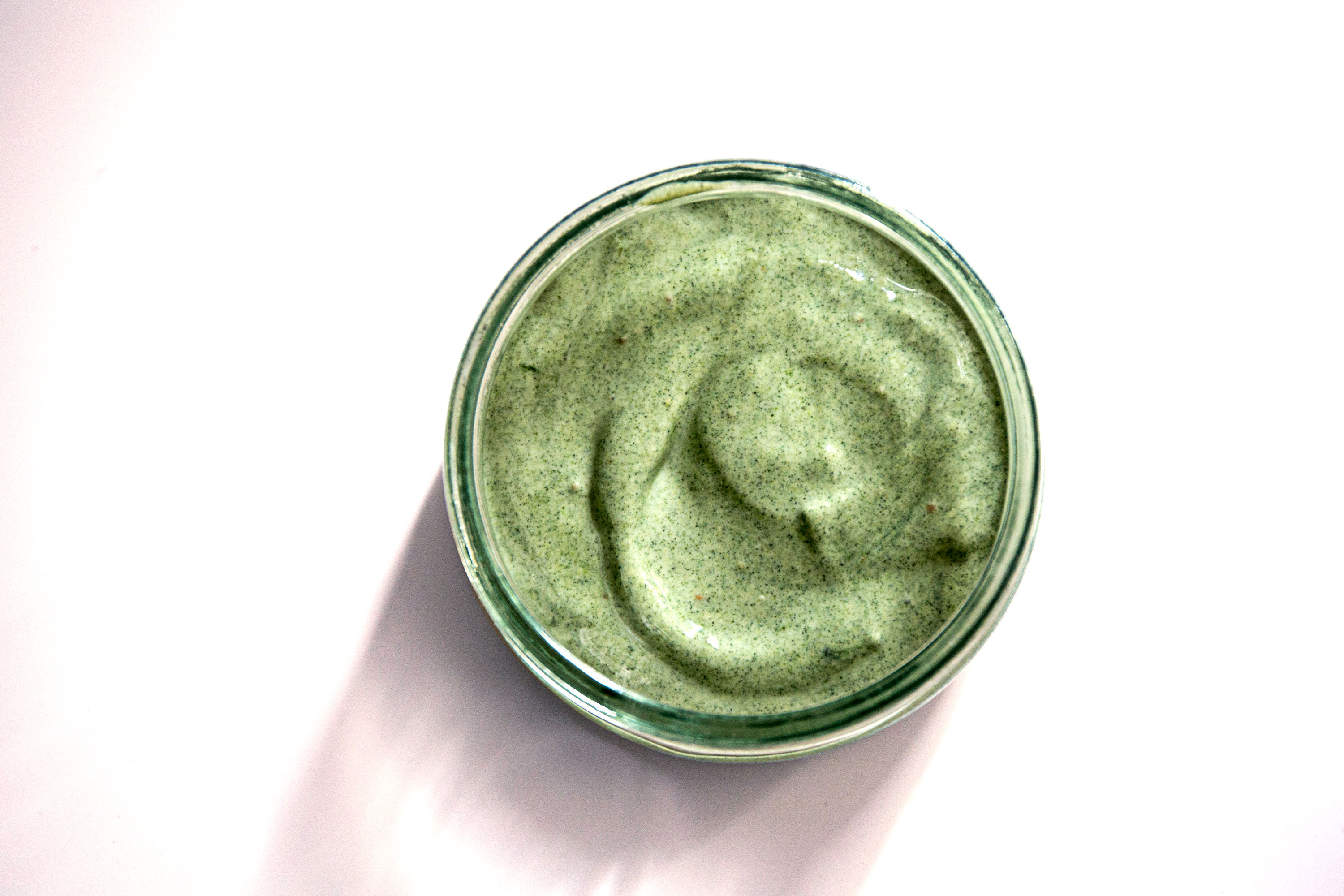 overhead shot of a green smoothie in a cup with a white background