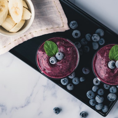 blueberry smoothie with fresh blueberries and banana slices
