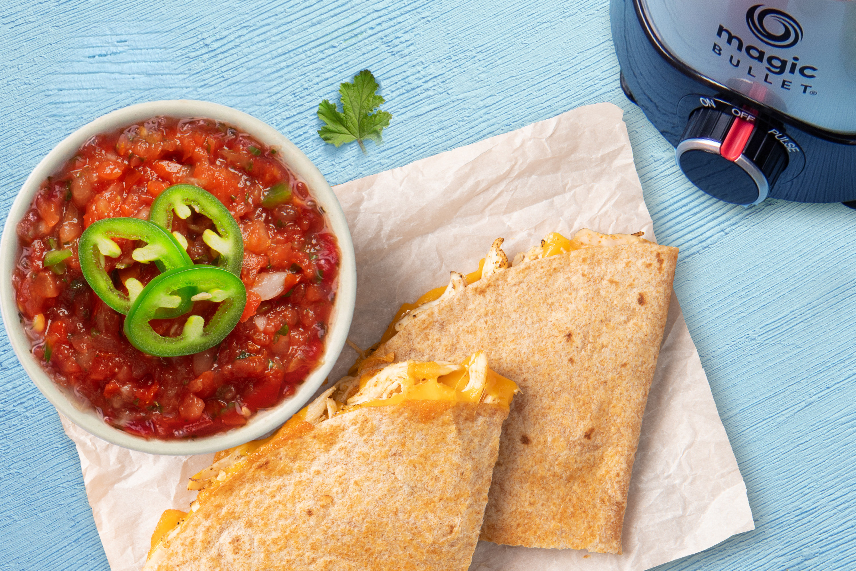 bowl of homemade red salsa with chicken quesadilla