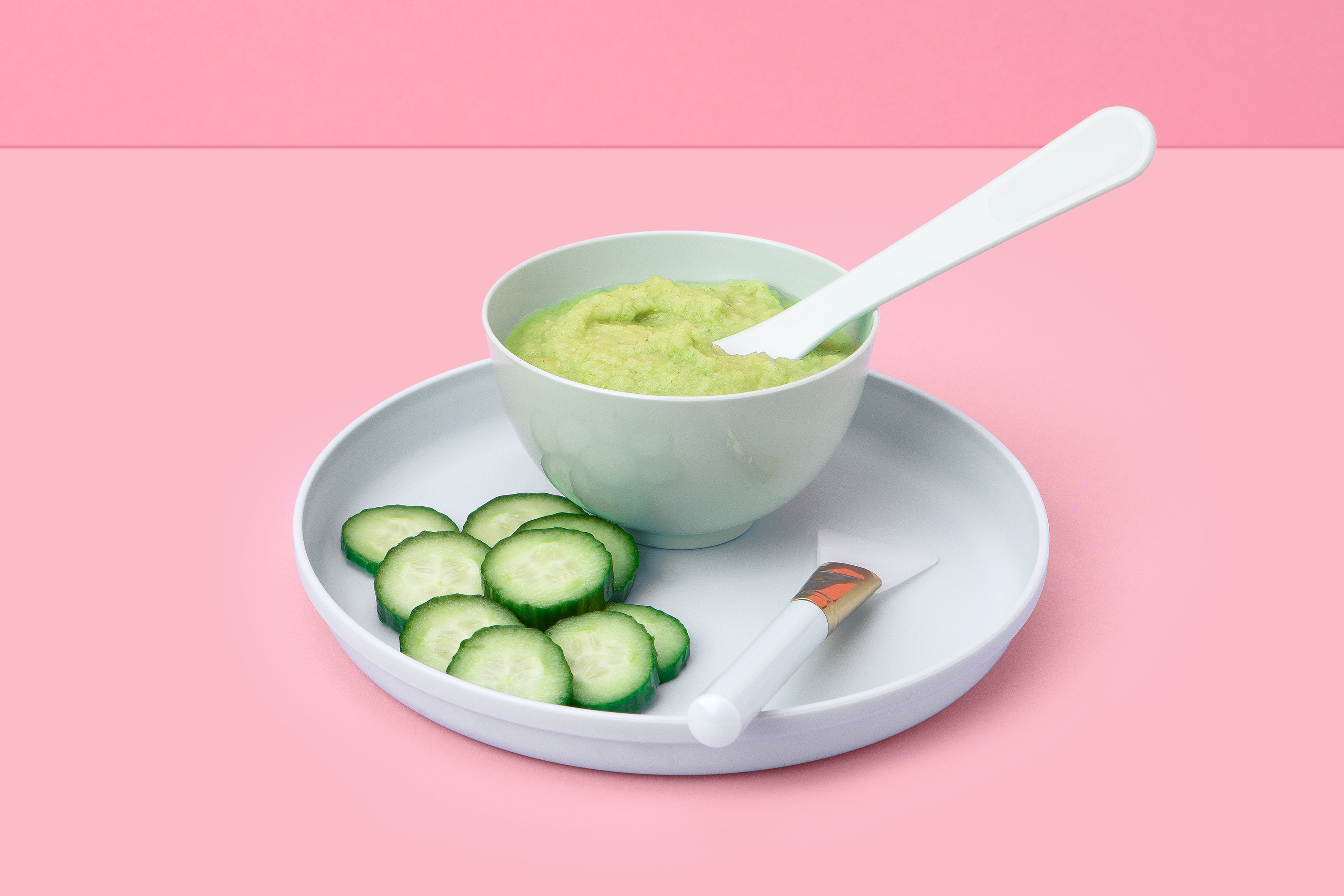 bowl of cucumber and celery face mask with sliced cucumber and brush