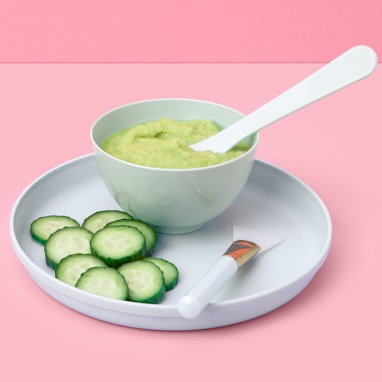 bowl of cucumber and celery face mask with sliced cucumber and brush