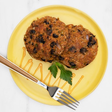 yellow plate of veggie patties with black beans