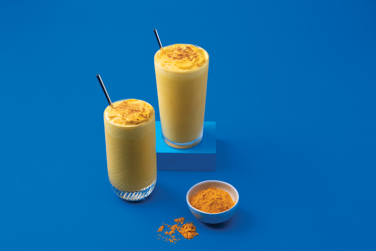cups of golden milk blended beverages with ground turmeric