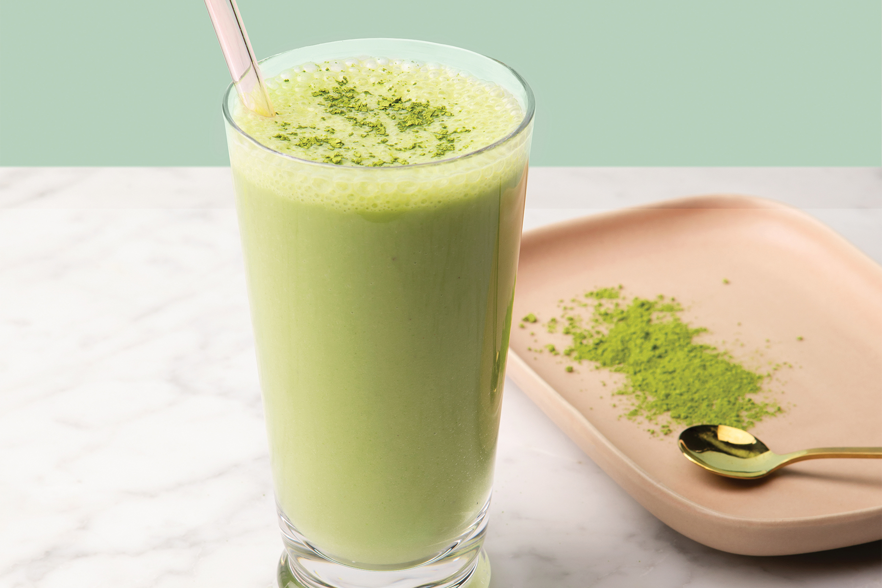 cup of coconut matcha smoothie with matcha powder