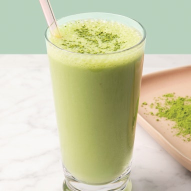 cup of coconut matcha smoothie with matcha powder