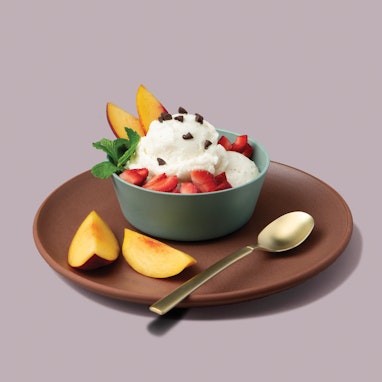 bowl of banana vanilla ice cream with fresh berries, nectarine, and cacao nibs