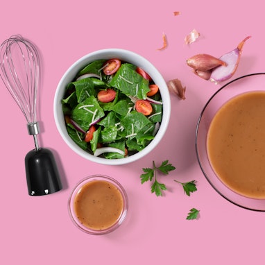 bowl of spinach and tomato salad with balsamic dressing and immersion blender attachment