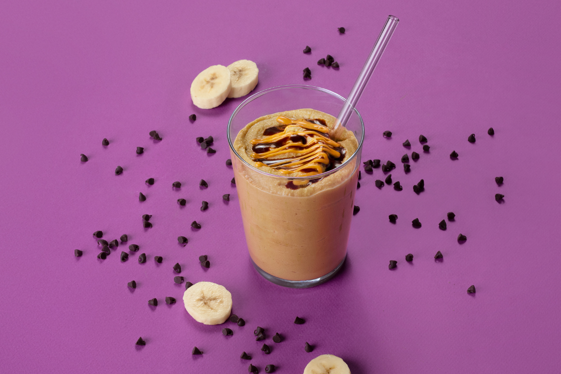 cup of chocolate banana smoothie with banana slices and chocolate chips