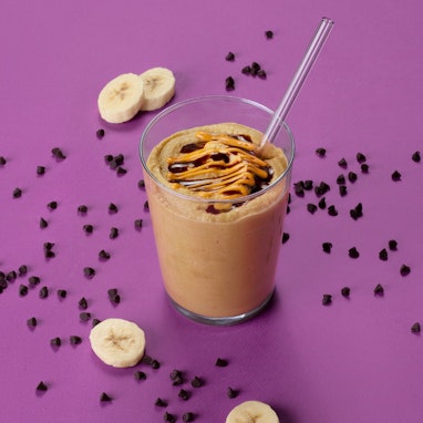 cup of chocolate banana smoothie with banana slices and chocolate chips