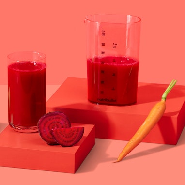 cup of vibrant red juice with beet, carrot, and green apple