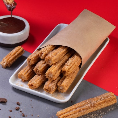 bag of churros with chocolate dipping sauce