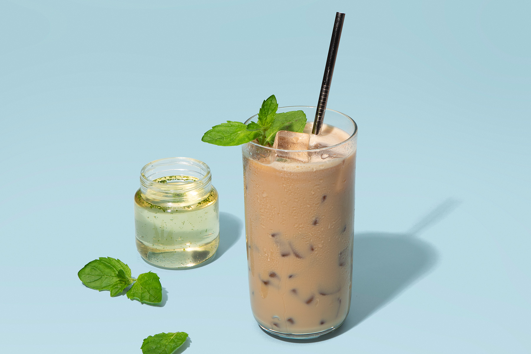 glass of ice latte with mint syrup and fresh mint leaves