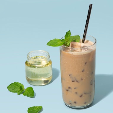 glass of ice latte with mint syrup and fresh mint leaves