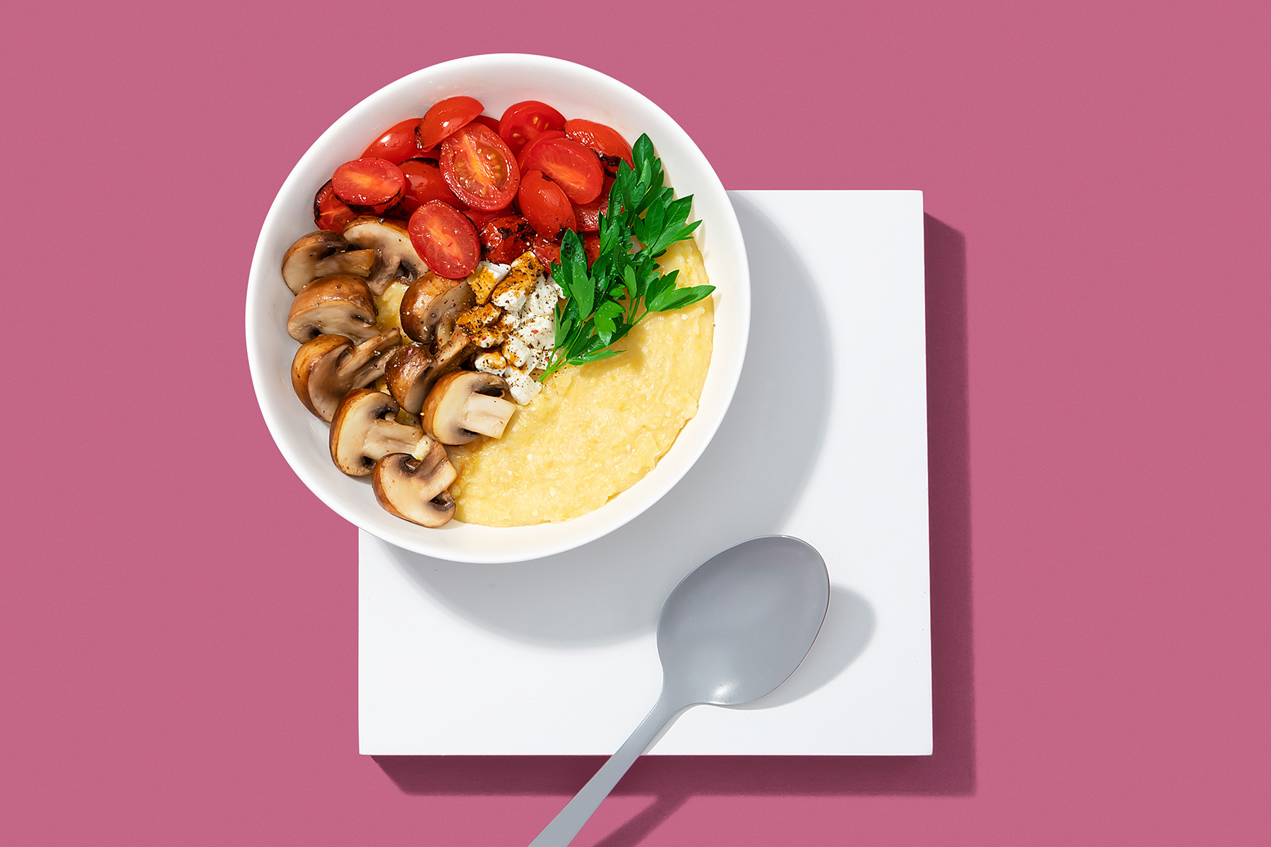 bowl of polenta with roasted mushrooms, tomatoes, and goat cheese