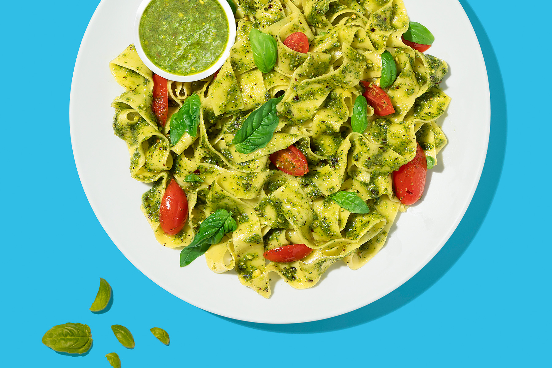 plate of pasta with arugula pesto and cherry tomatoes