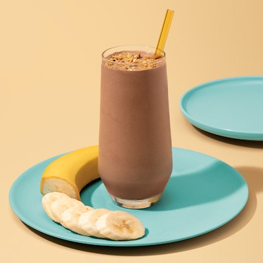 tall glass of blended coffee beverage with banana slices