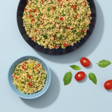 two bowls of tabbouleh with tomatoes and herbs